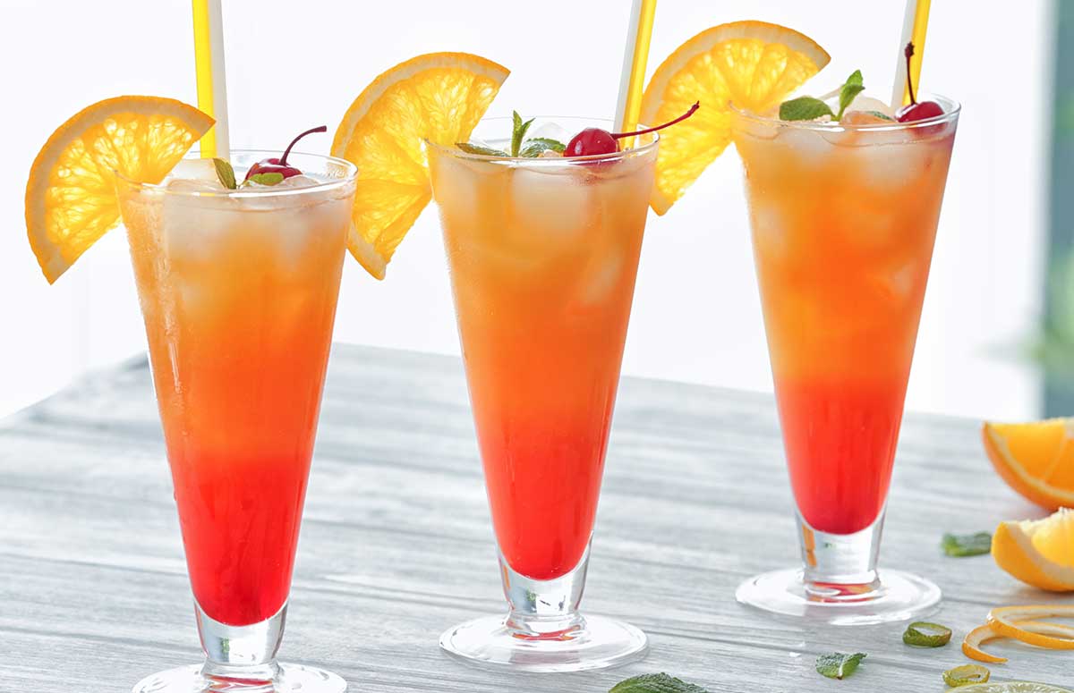 three red and orange 被喂春药蹂躏的欲仙欲死视频 sunrises in a glasses with orange wedges