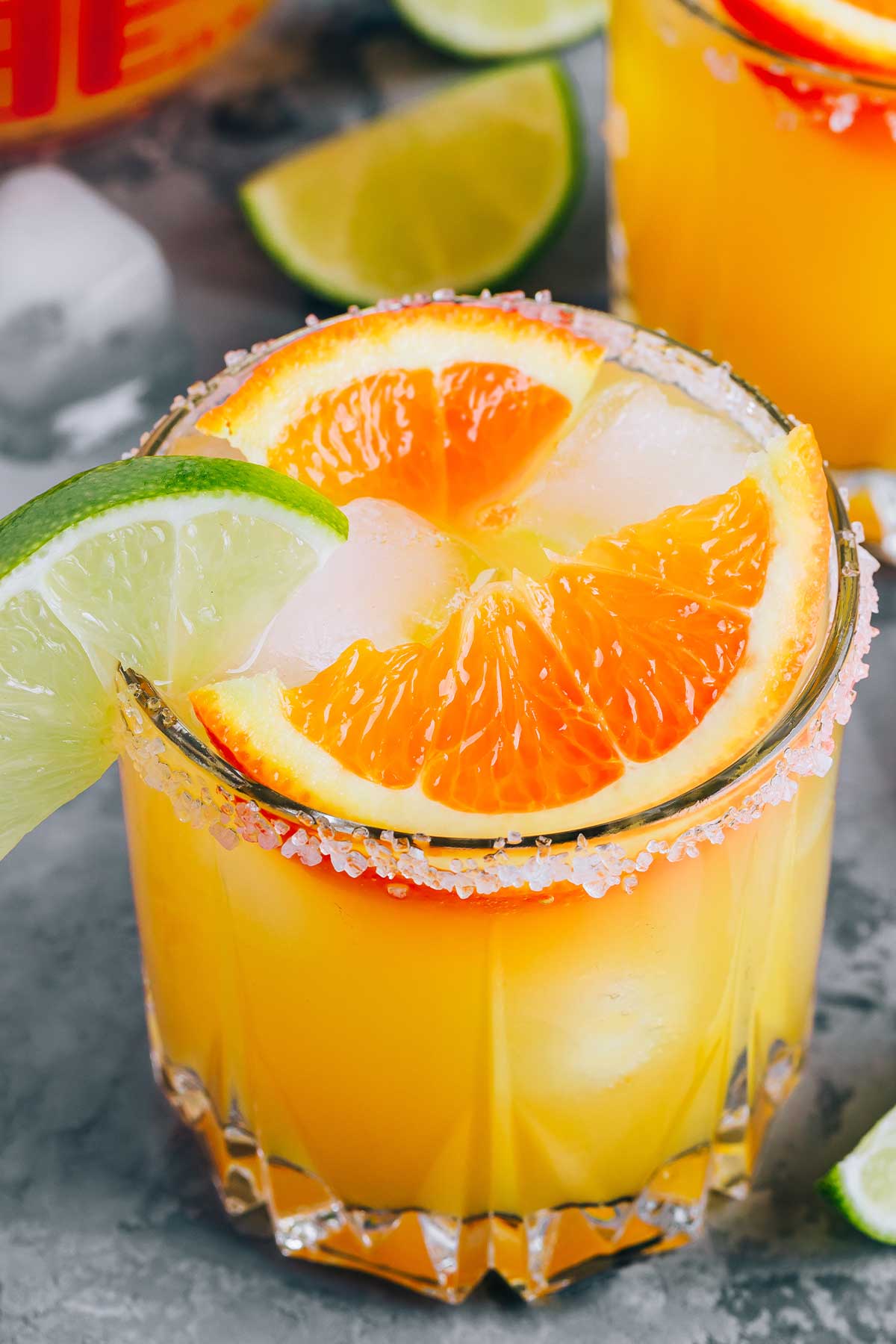 a glass of orange 亚洲性色成人av天堂 with orange and lime wedges on the rim