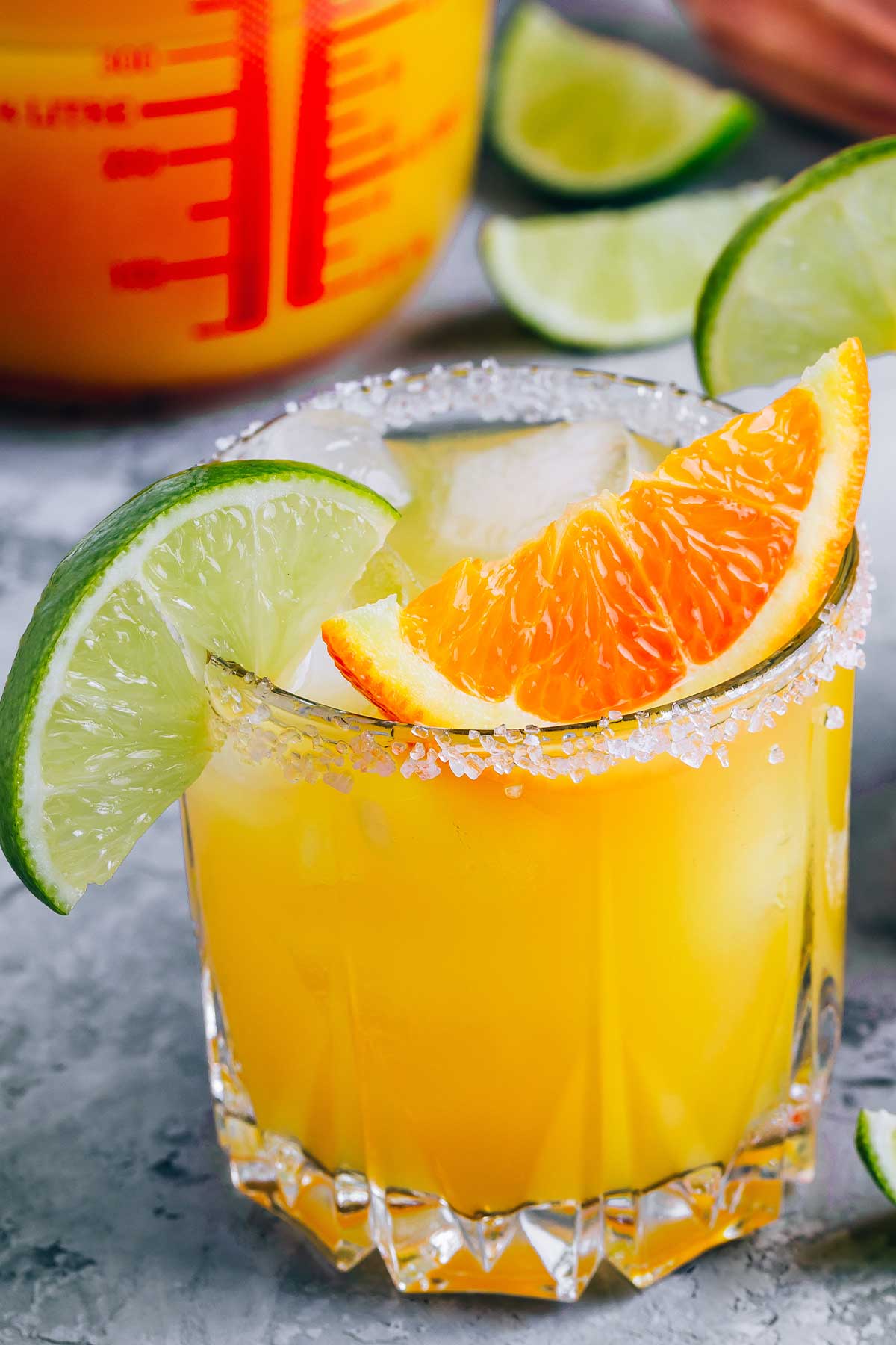 a glass of orange 亚洲性色成人av天堂 with orange and lime wedges on the rim