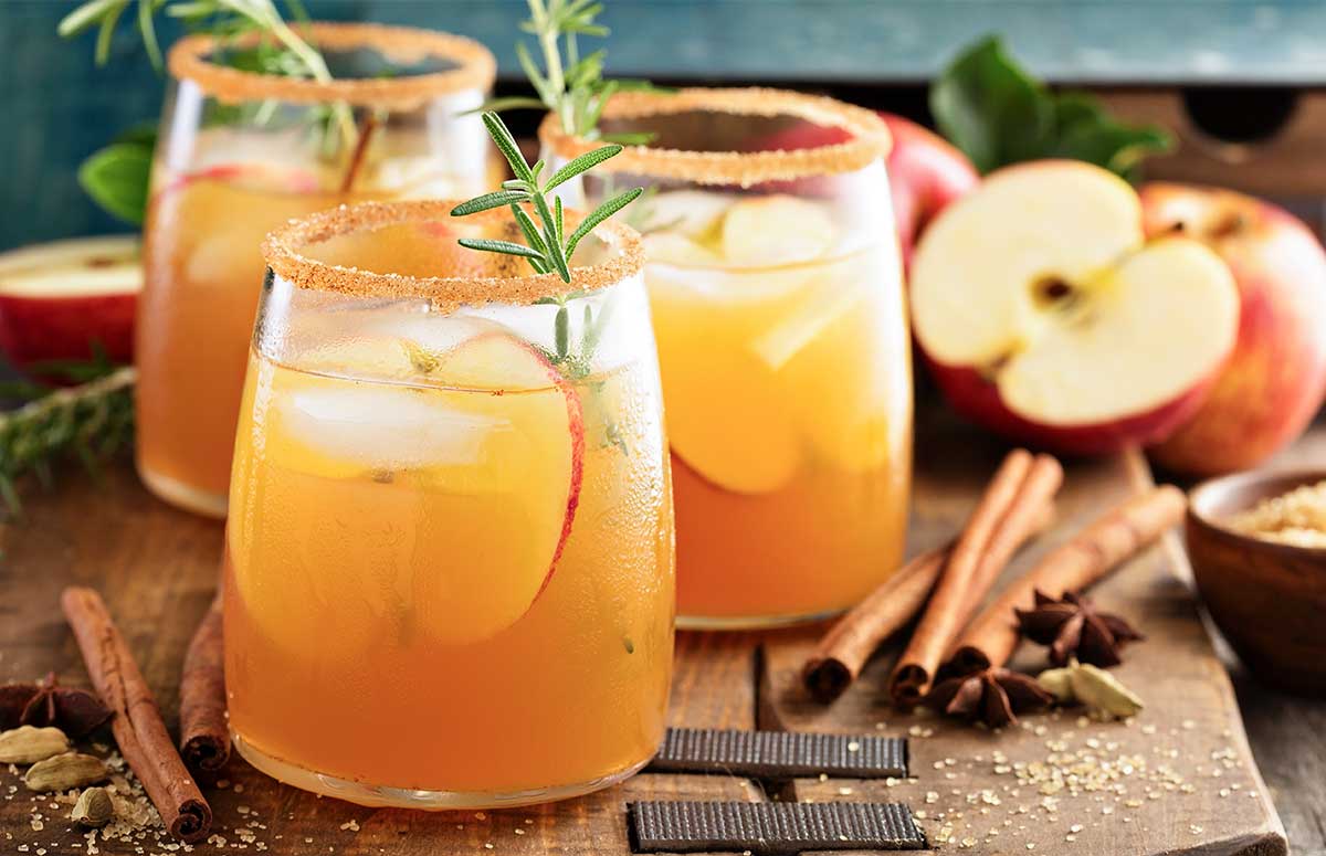 Thanksgiving 《漂亮的女邻居》韩剧免费 mixture served in three glasses rimmed with cinnamon sugar and garnished with sliced apple, cinnamon stick, and a sprig of rosemary. Extra 国产永久免费裸体美女视频 on a wooden kitchen board.