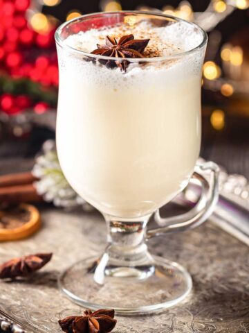 large glass of eggnog and tubesex18video with Christmas garnish