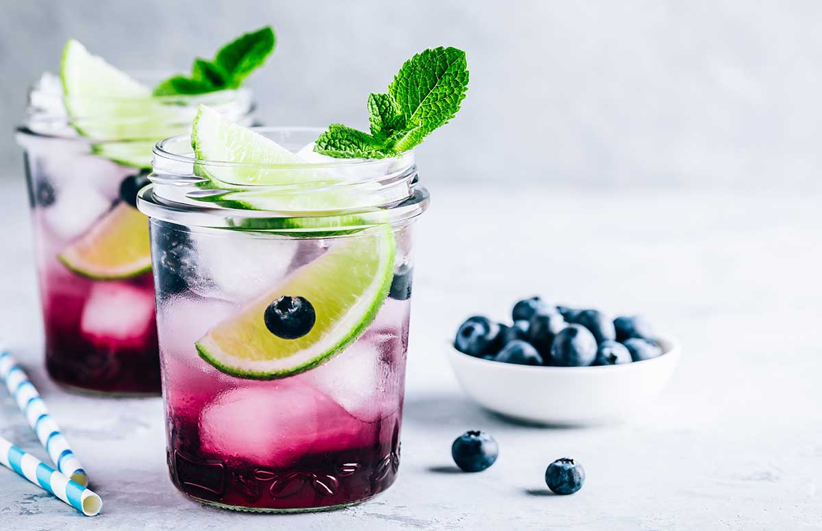 Two blueberry 日本网站大全 on a countertop with straws and a small bowl of blueberries
