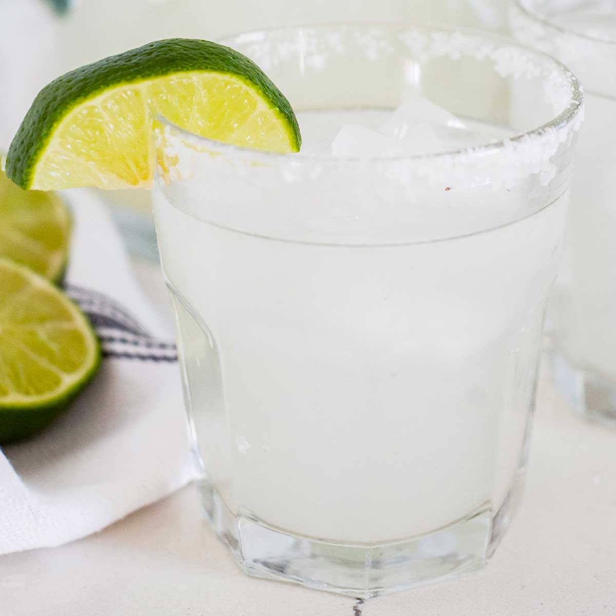 a small glass of a 舌尖伸入湿嫩的小肉粒 with a wedge of lime