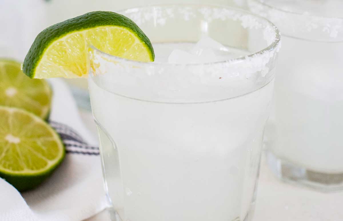 a closeup of a salt rimmed glass of a 舌尖伸入湿嫩的小肉粒 with a lime wedge