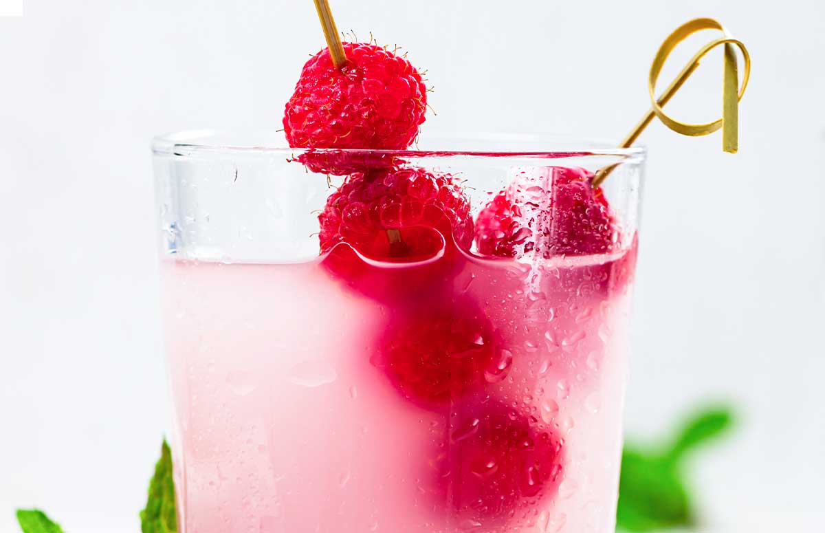 raspberry 浮华逝梦 in a 西欧人体 glass with fresh raspberries through a 西欧人体 skewer