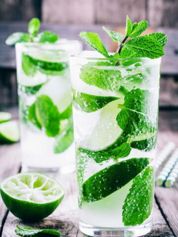 two glasses filled with a asaakira mojito 精品免费视频 and mint leaves