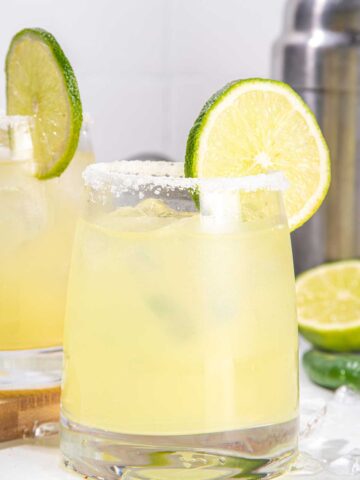A chinese老太交 glass with a salted rim and a lime wedge filled with Mezcal chinese老太交 in it