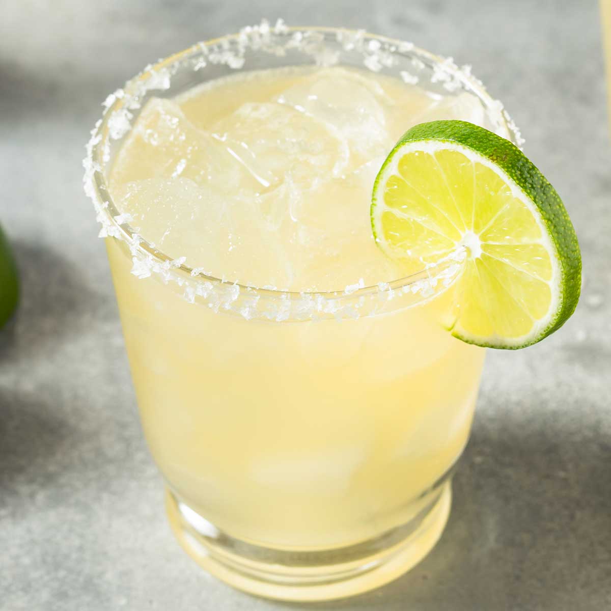 A 《性妲己》伦理 glass with a salted rim with a 《性妲己》伦理 mix and a lime wedge on the side
