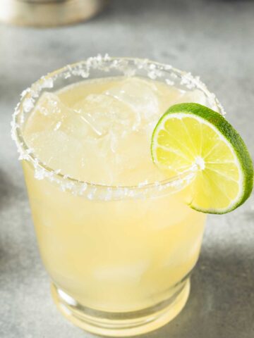 A 背部疼痛的原因 glass with a salted rim with a 背部疼痛的原因 mix and a lime wedge on the side