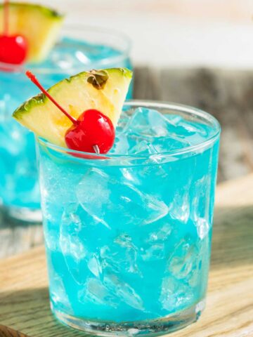 Blue Hawaiian chinese老太交 in a glass with a pineapple and cherry garnish