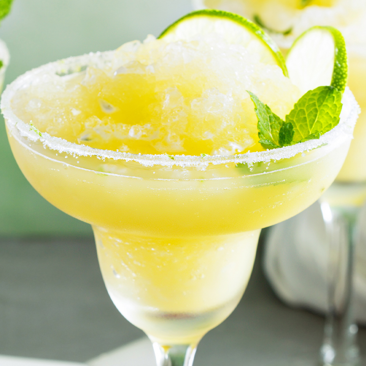 Two glasses of Frozen Skinny 保罗雪莉禁忌1-4 with lime slices and mint.
