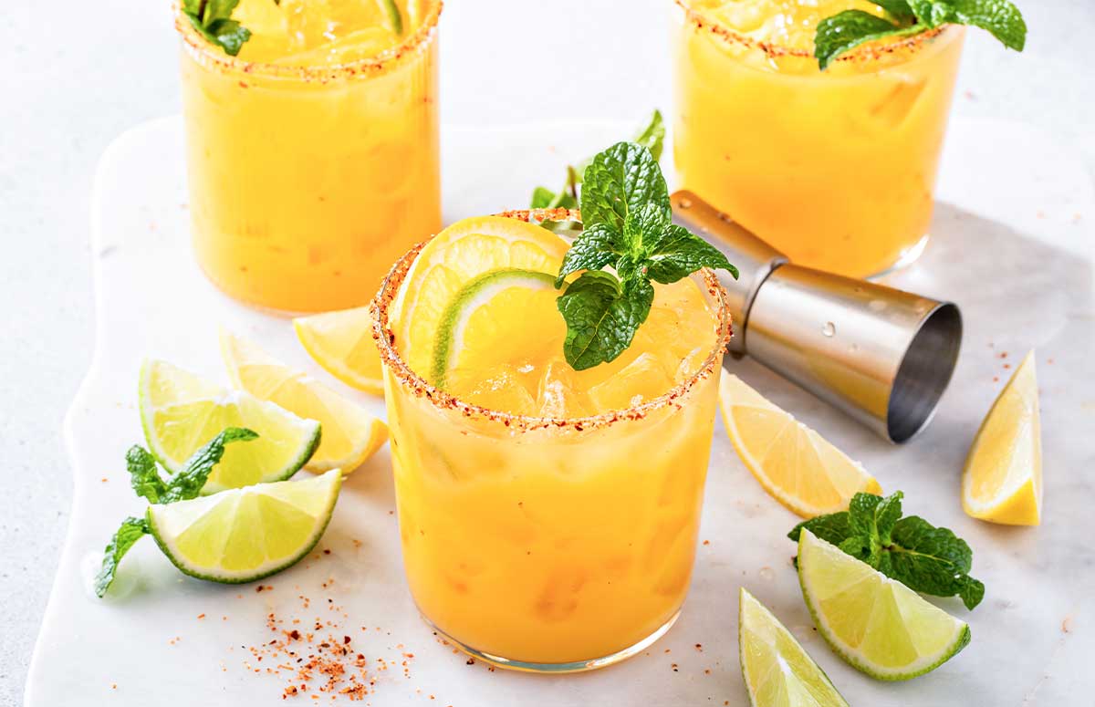 Skinny Orange 性调教室高h学校 with Tajin rim, orange and lime slices, and mint sprig.
