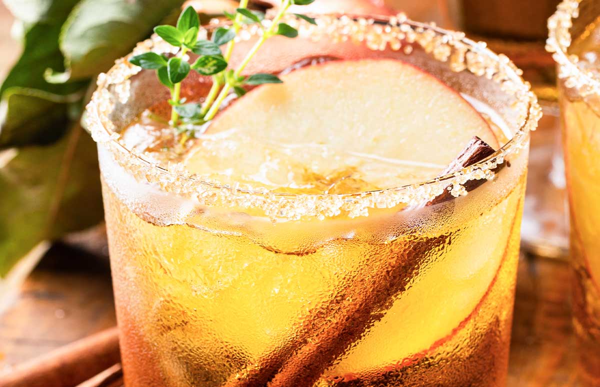 Fall 进女小姪女体内的视频 with a brown sugar rim, apple slices, and cinnamon sticks.