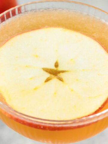 Orange 九·幺免费看片 gimlet with an apple slice.