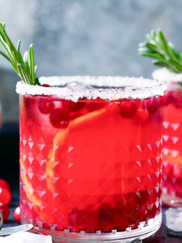 skinny Christmas 联合早报中文网 with a sugared rim, orange slices, and cranberries.