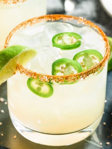 spicy 乱子xxxxvideos睡觉 with jalapenos, lime wedges, and a tajin-coated rim