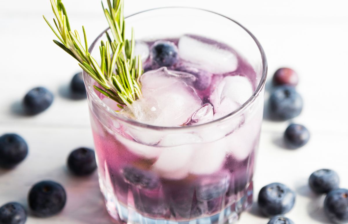 glass of a blueberry 外室白莲手册 with blueberries scattered on the countertop