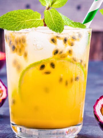 small glass of an orange passion fruit 甘肃信鸽信息网最大门户网站 garnished with a striped green straw